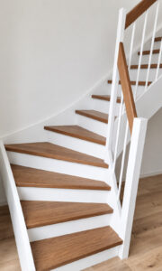 Holztreppe mit Eichenstufen, weißem Geländer und Eichenhandlauf